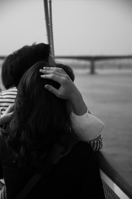 Man holding woman on a boat at sunset